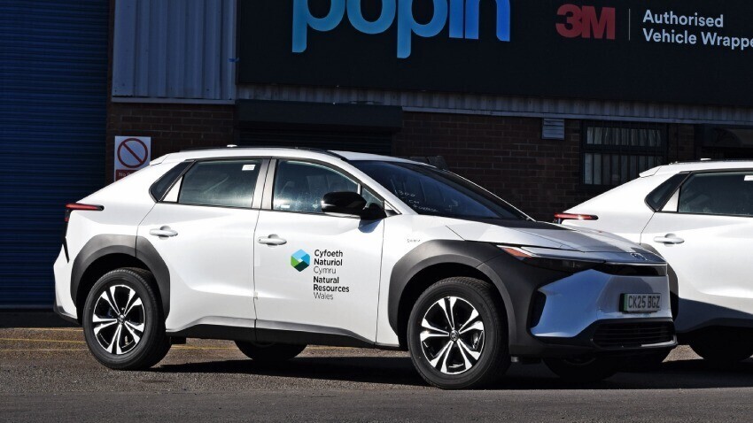 Branded vinyl graphics on white Toyota BZ4X company car outside Popin in Cardiff.