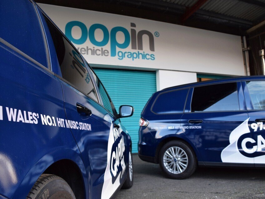 Fleet of company cars with matching vehicle wraps and graphics outside Popin in Cardiff.
