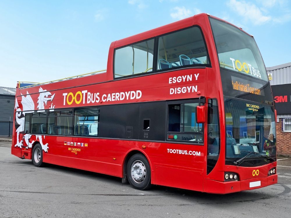 Red livery and vehicle graphics on Ayats Bravo city Tootbus open top tour bus.