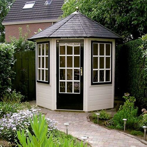 Charming octagonal garden building with a classic pitched roof, painted in a light cream finish with contrasting black accents on the door and window frames. The building features traditional Georgian-style windows, including a glass-panelled door, creating a bright and airy interior. Nestled in a lush garden surrounded by greenery, the structure is accessible via a winding brick pathway lined with small outdoor lights. Designed and installed by Forever Timber, this elegant building is perfect as a summerhouse, reading nook, or tranquil retreat, blending timeless design with modern craftsmanship.