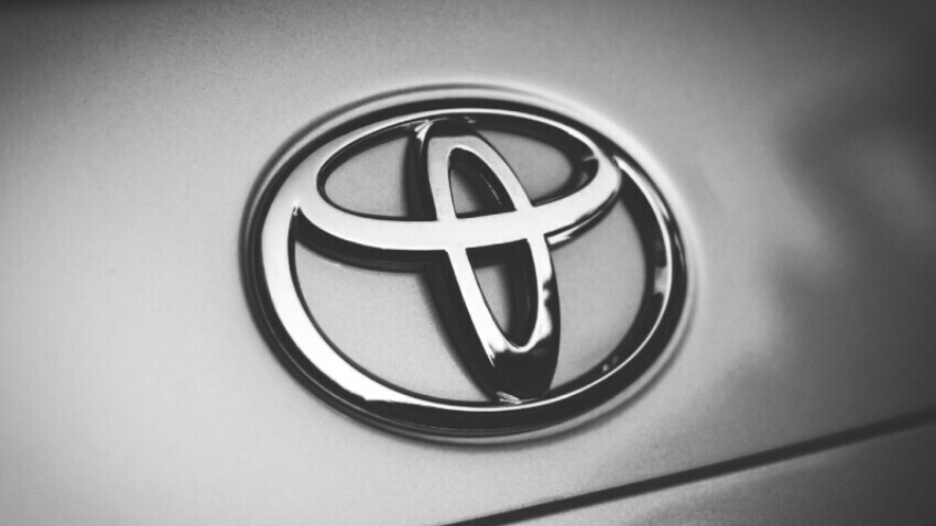 Toyota badge on front of silver company car.