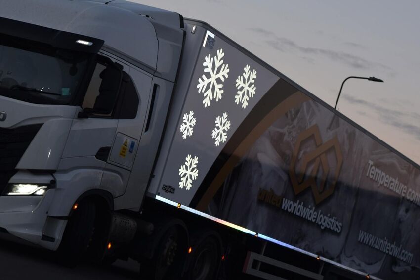 Reflective vinyl graphic elements on Iveco delivery truck for night-time brand marketing.