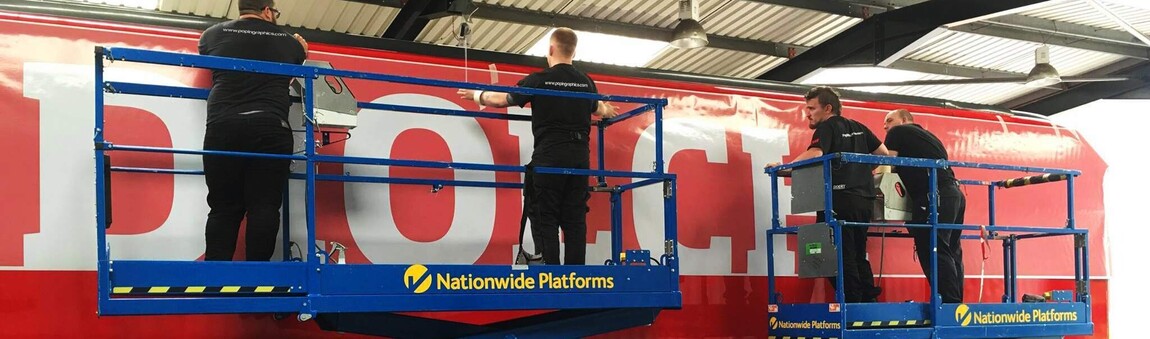 Temporary branded vinyl wrap being applied to commercial coach at Popin in Cardiff.