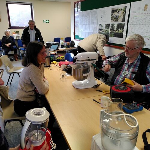 Repair Hub volunteers working at busy meeting