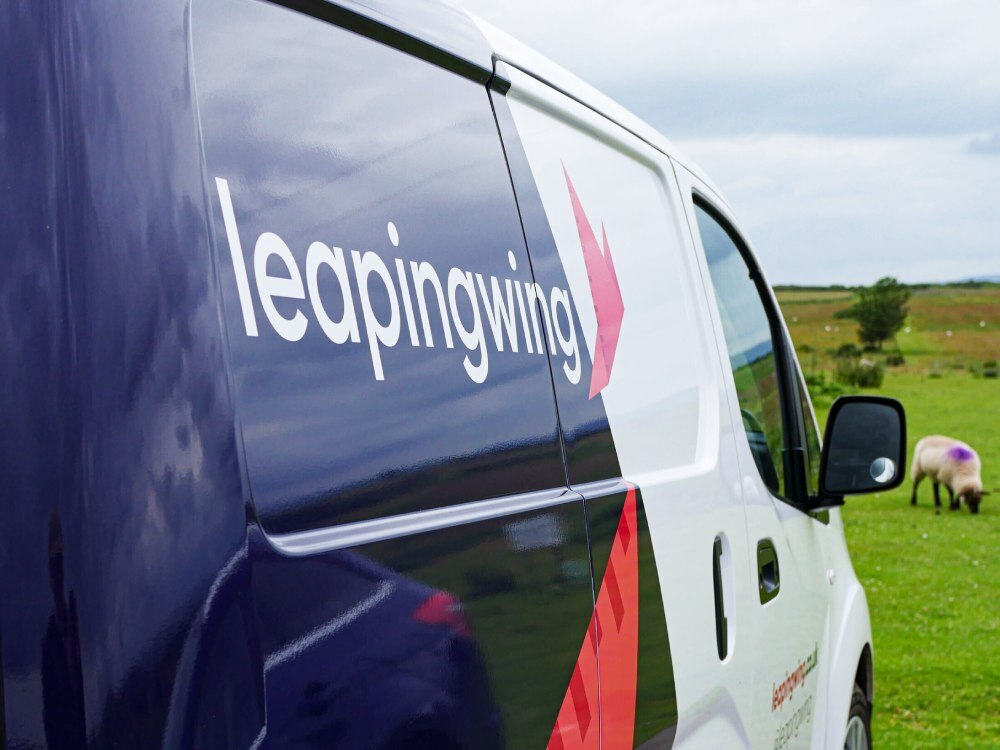 Close up of Leaping Wing branded livery on Nissan e-NV200 electric company van.