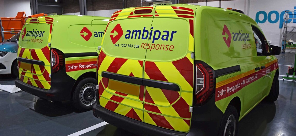 Fleet of branded business work vans with fluorescent wraps and UK compliant reflective safety markings.
