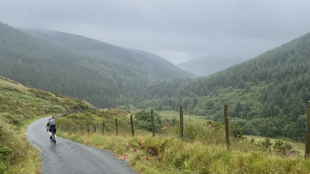 A cyclist riding along a scenic road in the Brecon Beacons countryside 