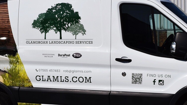 Company van with partial vehicle wrap and graphics of social media icons and QR code.