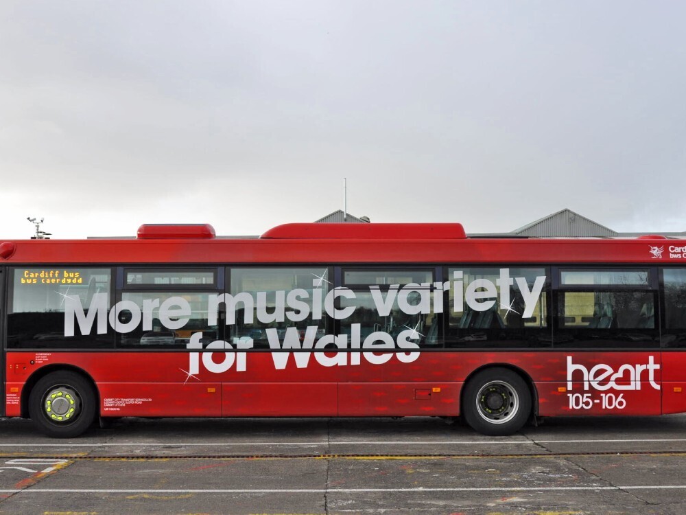 Red vehicle wrap and branded vinyl graphics on Scania Omnilink Cardiff Bus.