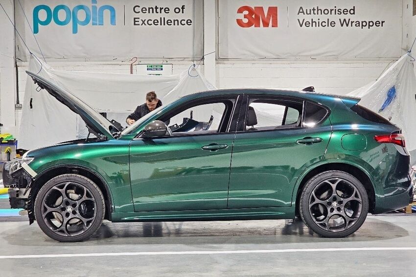 Protection wrap vinyl film being professionally installed onto a green Alfa Romeo Stelvio at Popin in Cardiff.