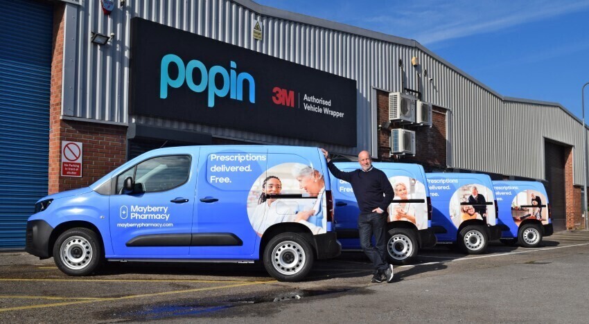 Managing Director of Mayberry Pharmacy stood outside Popin in Cardiff with newly wrapped fleet of company vans.