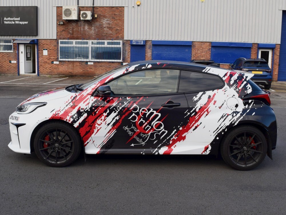 Black, red and white motorsport wrap design on a Toyota Yaris GR sports car