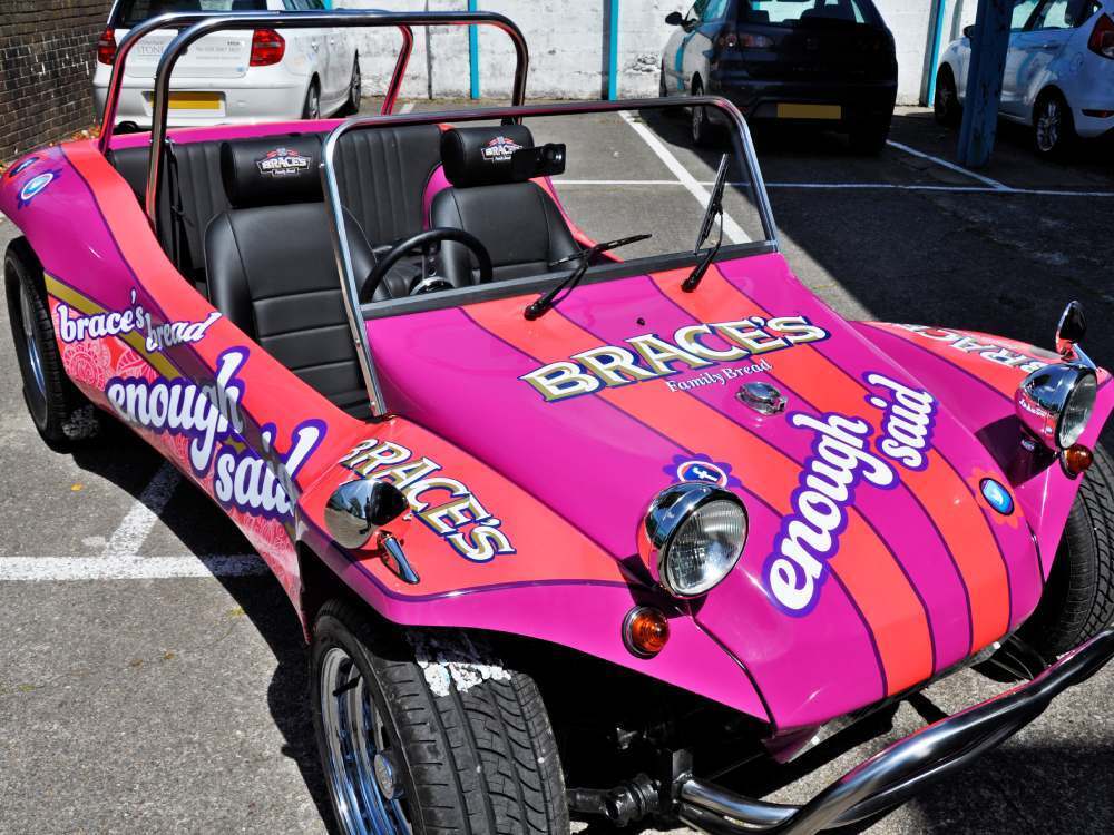 Braces Bread "Enough Said" pink vehicle livery on Volkswagen Meyers Manx company car.