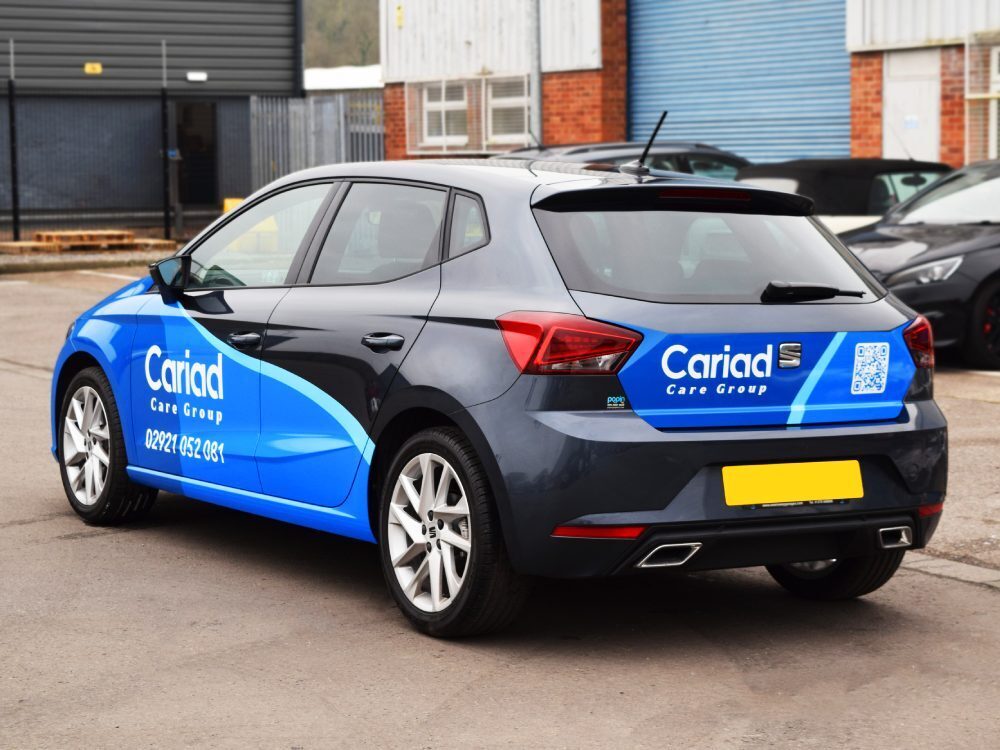 Blue and black vehicle wrap with branded vinyl graphics on SEAT Ibiza company car.