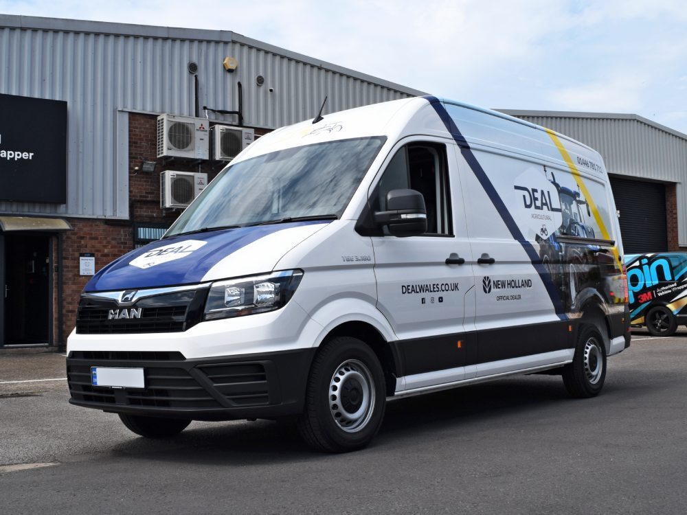 Partial branded vehicle livery on white company MAN TGE van.