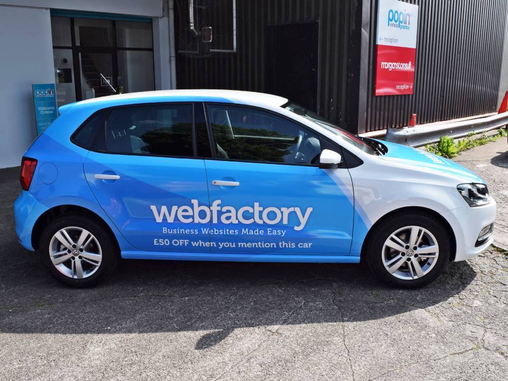 Volkswagen Polo company car with blue branded vehicle livery and graphics.