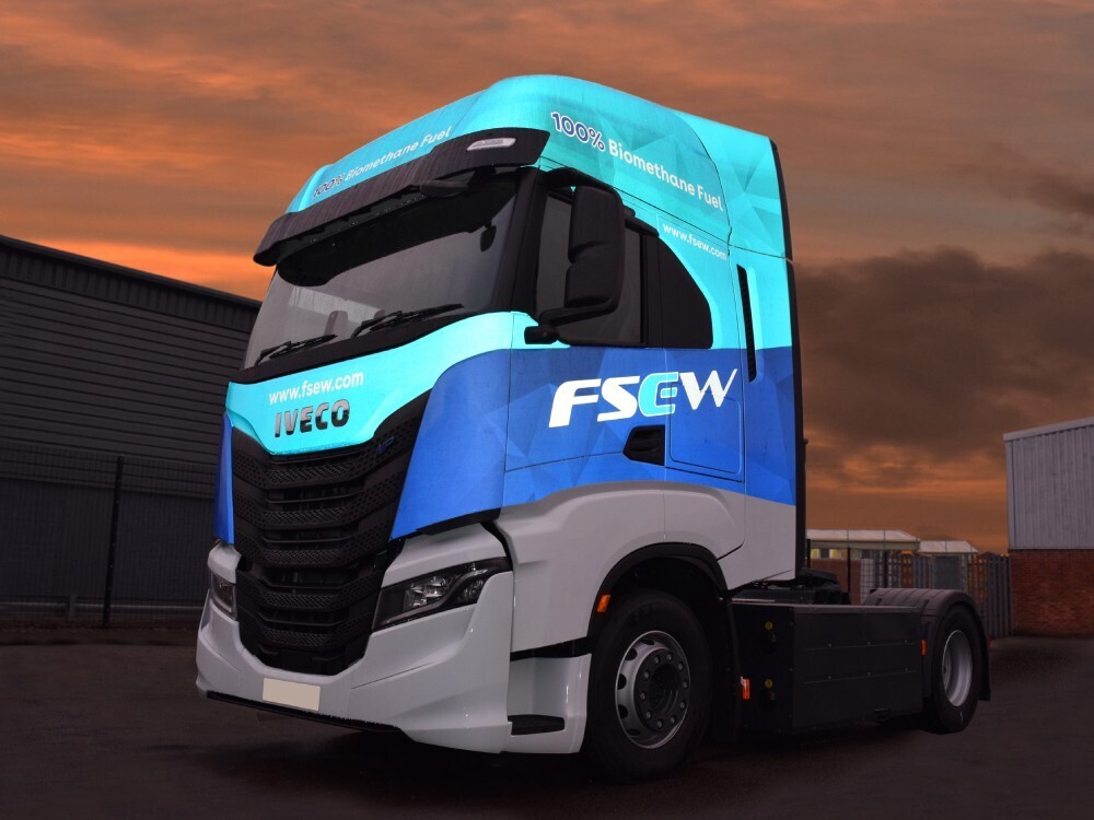 Reflective vehicle wrap and graphics on a blue and white Iveco lorry.