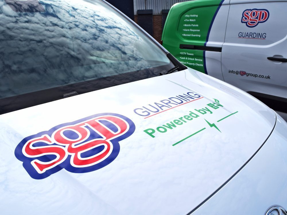 SGD branded vinyl graphics on front bonnet of fleet of white Toyota Proace City Verso electric company vans.