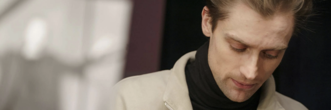 Man that is an actor looking down at script while talking to another person holding a script