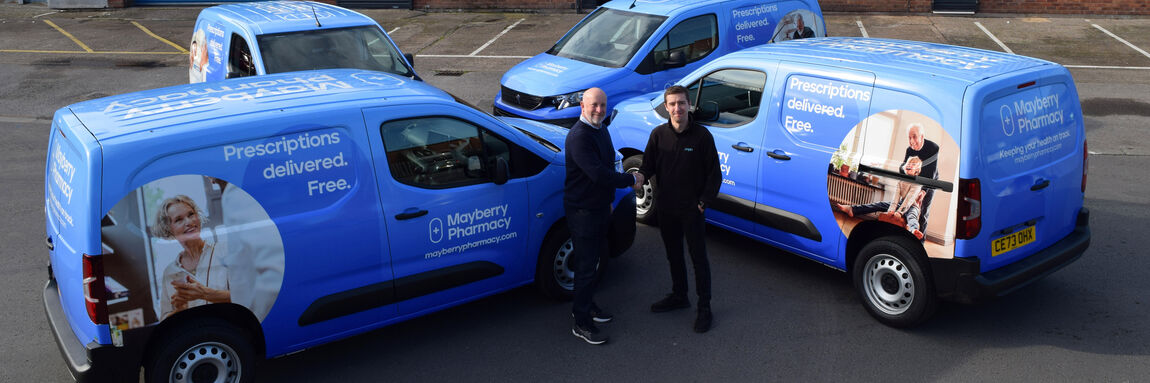 Businessmen shaking hands with their newly wrapped fleet of vans