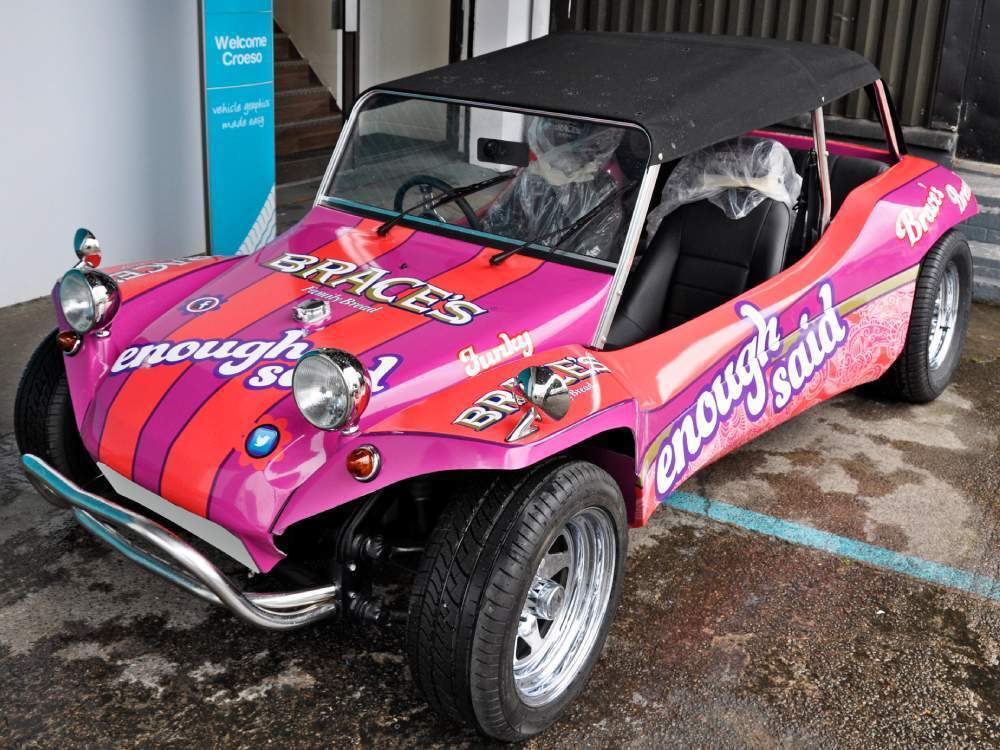 Pink Braces Bread "Enough Said" promotional vehicle wrap on Volkswagen Meyers Manx company car.