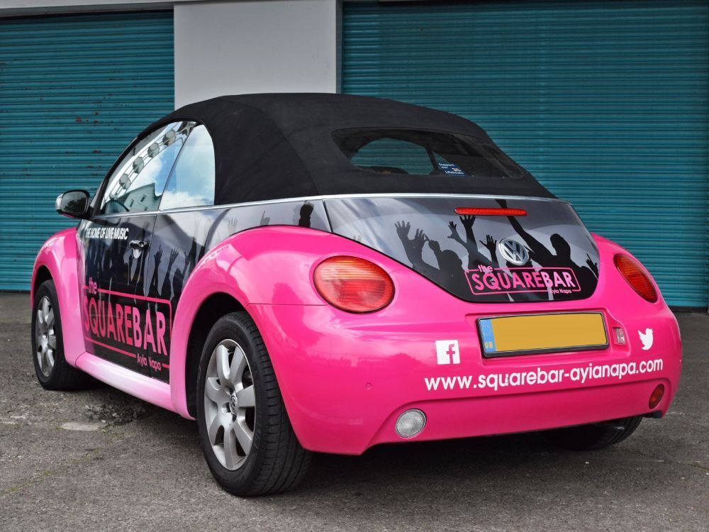Rear of pink Volkswagen Beetle company car with business branded vehicle wrap and vinyl graphics.