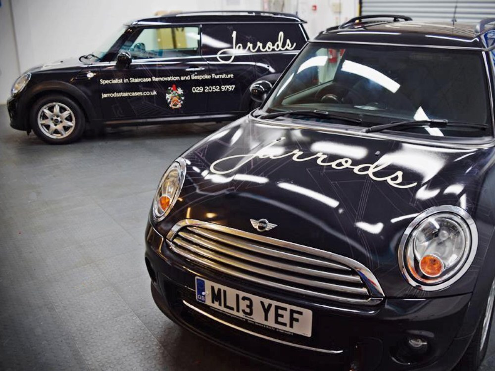 Fleet of company cars with matching branded vehicle wraps and graphics.