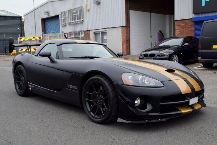 Matte black motorsport livery with two gold sport stripe graphics on Dodge Viper SRT10.