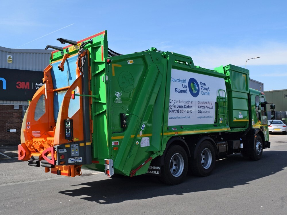 Green and orange vehicle wrap on the rear end of a Dennis truck.
