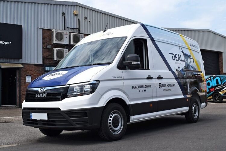 Partial vehicle wrap and graphics on a white company MAN TGE van.