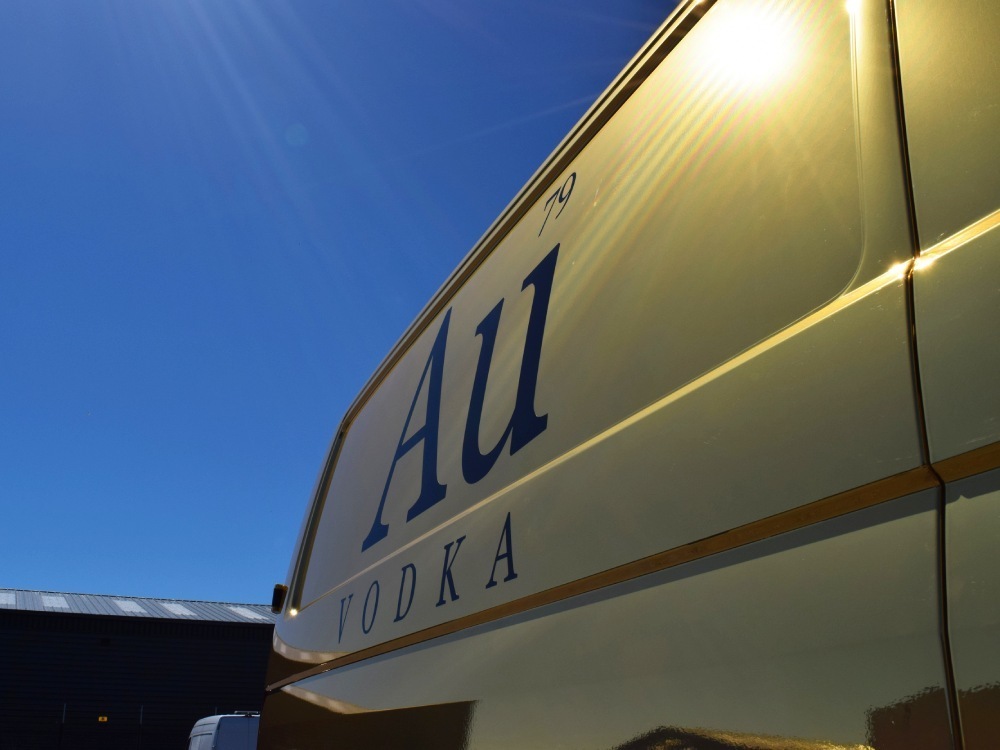 Black Au Vodka branded vinyl graphics on gold company Volkswagen Transporter van.