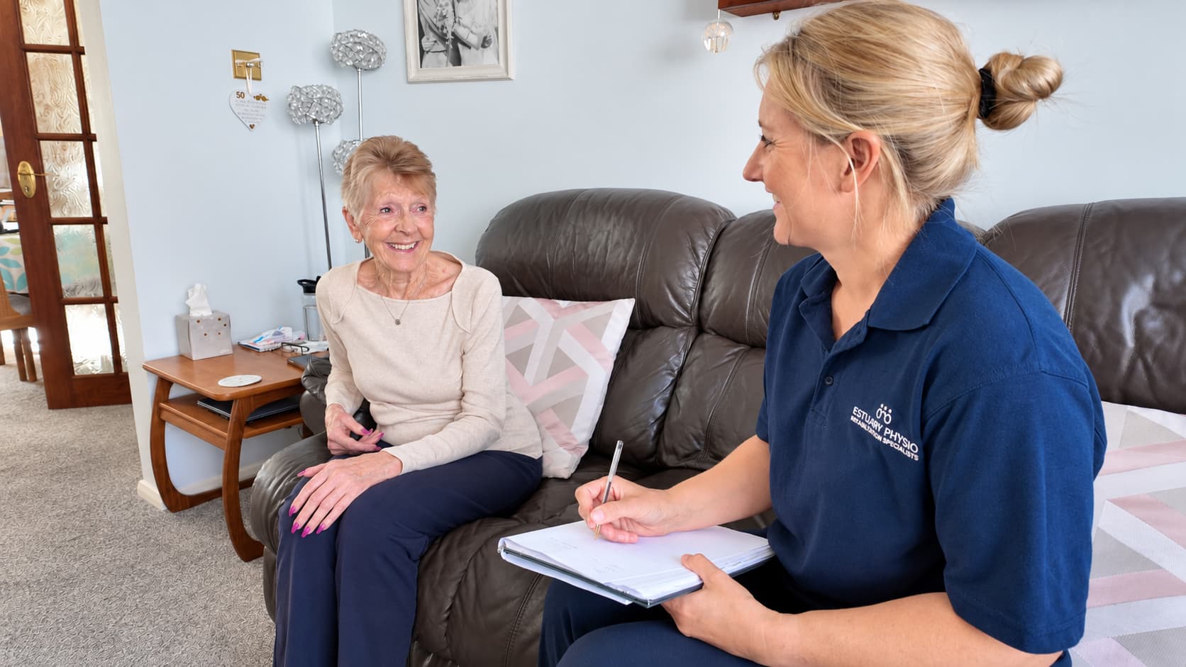 Physiotherapist listening to an older adult during an initial home visit conversation