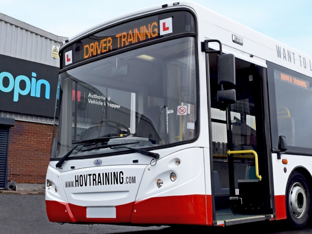 Branded vinyl graphics and red white livery on driver training Alexander Dennis Enviro 300 bus.