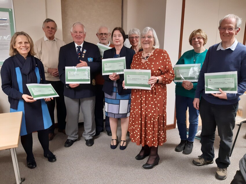 Community group representatives receiving their grant presentations from chair