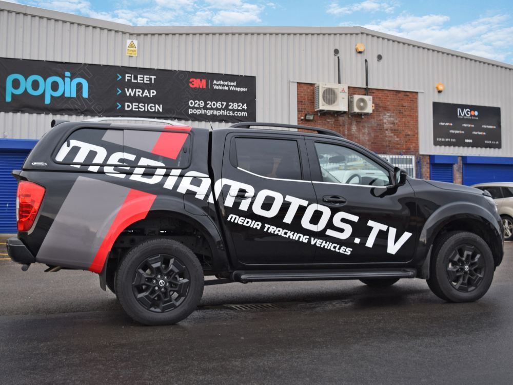 Branded vehicle graphics on black company Nissan Navara outside Popin wrap centre in Cardiff.