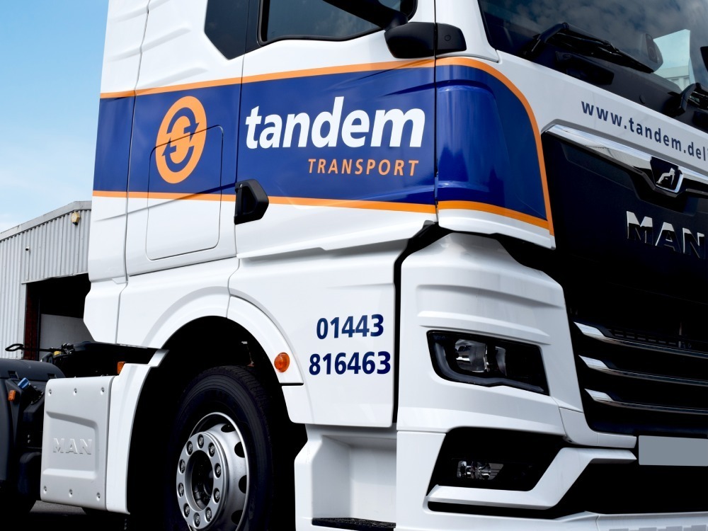 Vehicle graphics on the cab of a company MAN truck.