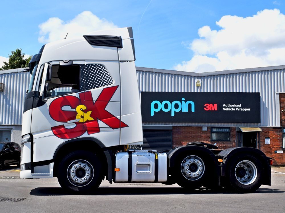 Volvo lorry with newly installed white vehicle wrap and company branded vinyl graphics outside Popin in Cardiff.