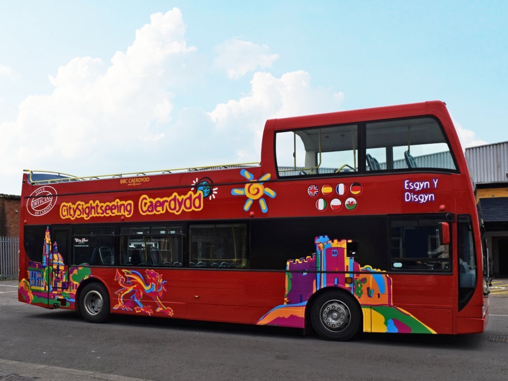 Red Optare VLE open top tour bus with Cardiff City Sightseeing promotional graphics.