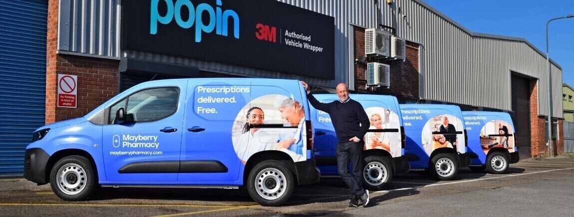 A proud business owner with his fleet of professionally wrapped company vans outside Popin in Cardiff.