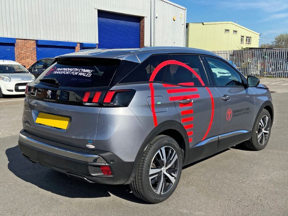 Silver Peugeot 3008 company car with red brand logo vinyl graphics.