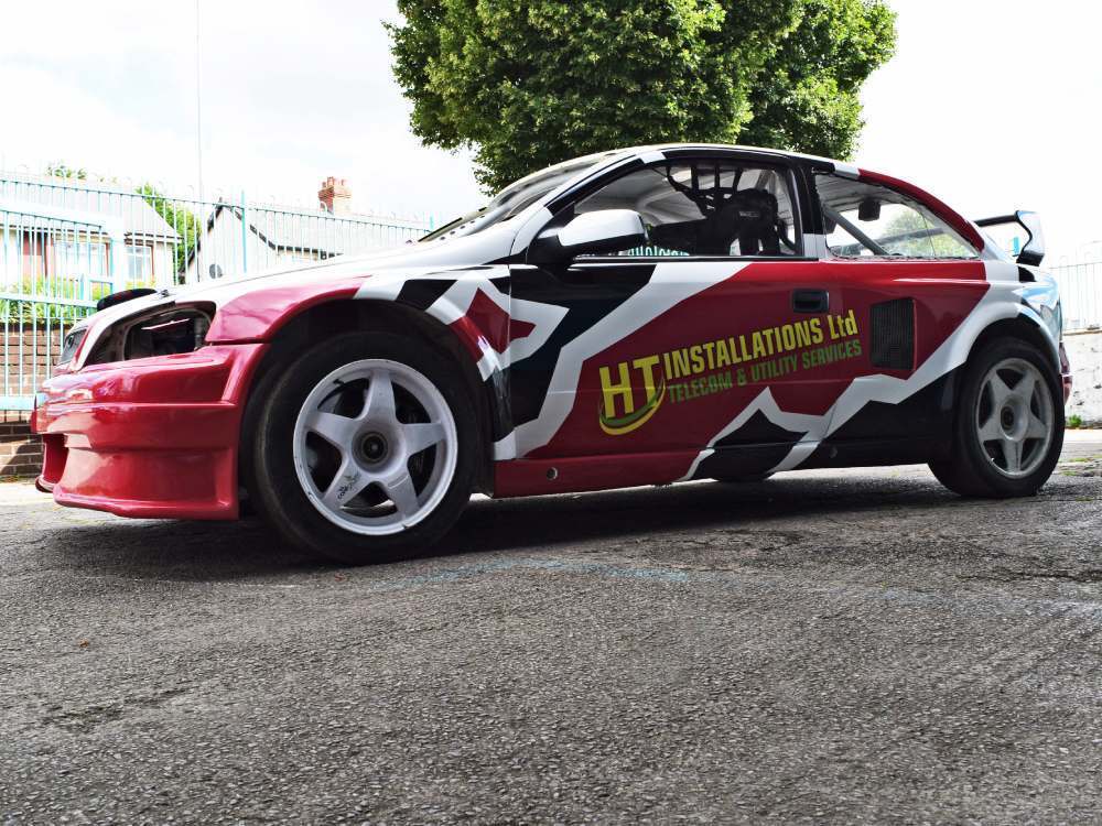 Red, black and white vehicle wrap and branded graphics on Vauxhall Astra company car.