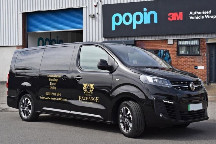 Branded gold vinyl graphics on Vauxhall Vivaro van outside Popin vehicle wrap facilities in Cardiff.