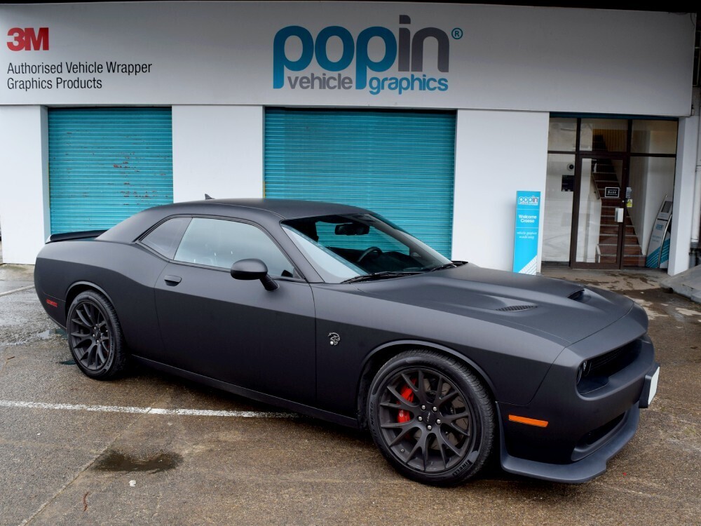 Matte black motorsport wrap on Dodge Challenger Hellcat sports car