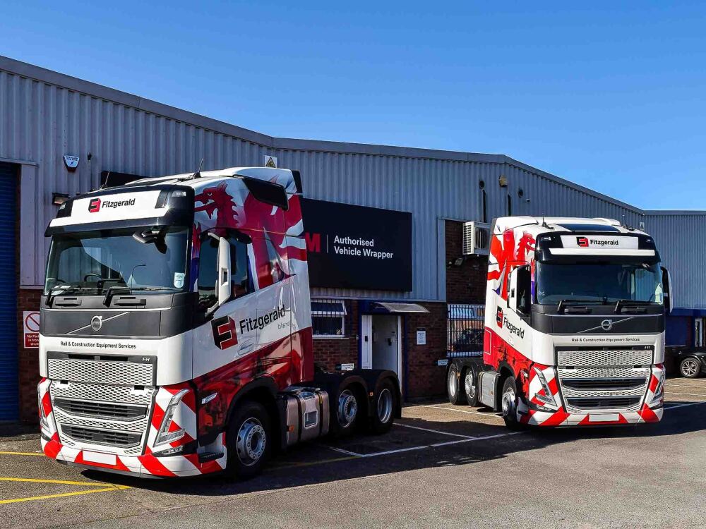 Fleet of Volvo FH4 lorries with red and white vehicle wraps and branded commercial graphics for Fitzgerald Plant Services.
