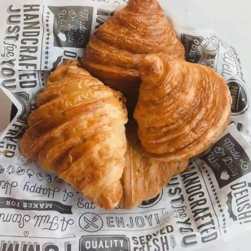 Croissant on printed greaseproof paper