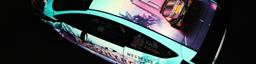Highly reflective vehicle wrap on a car illuminated in the dark by a flash.