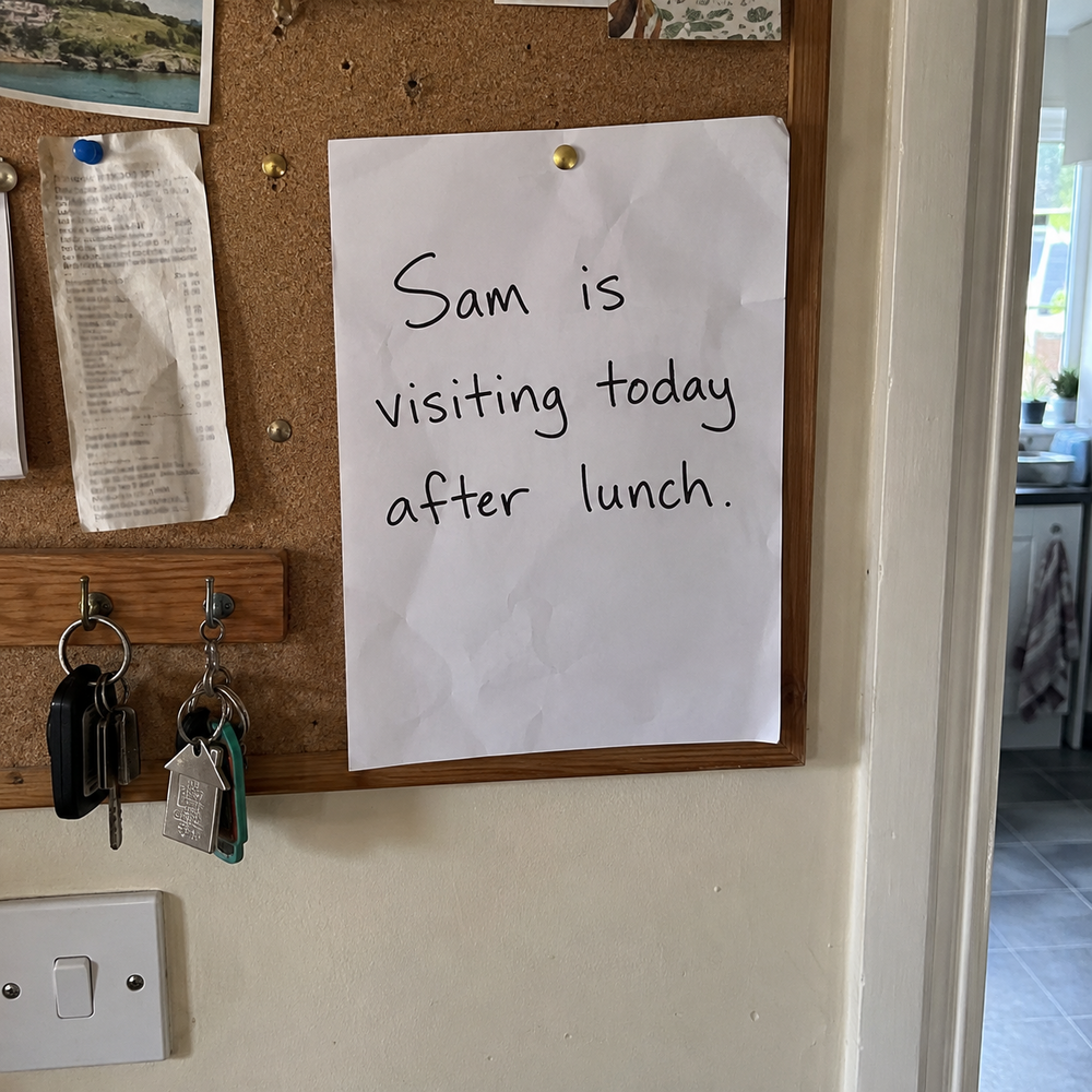Handwritten note on a home noticeboard reading “Sam is visiting today after lunch.”