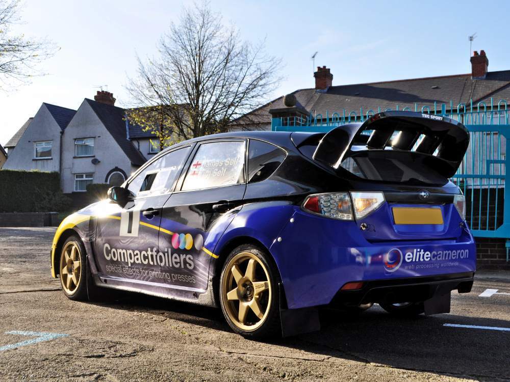 Rear of Subaru Impreza B13 company car with vehicle wrap and branded vinyl graphics.