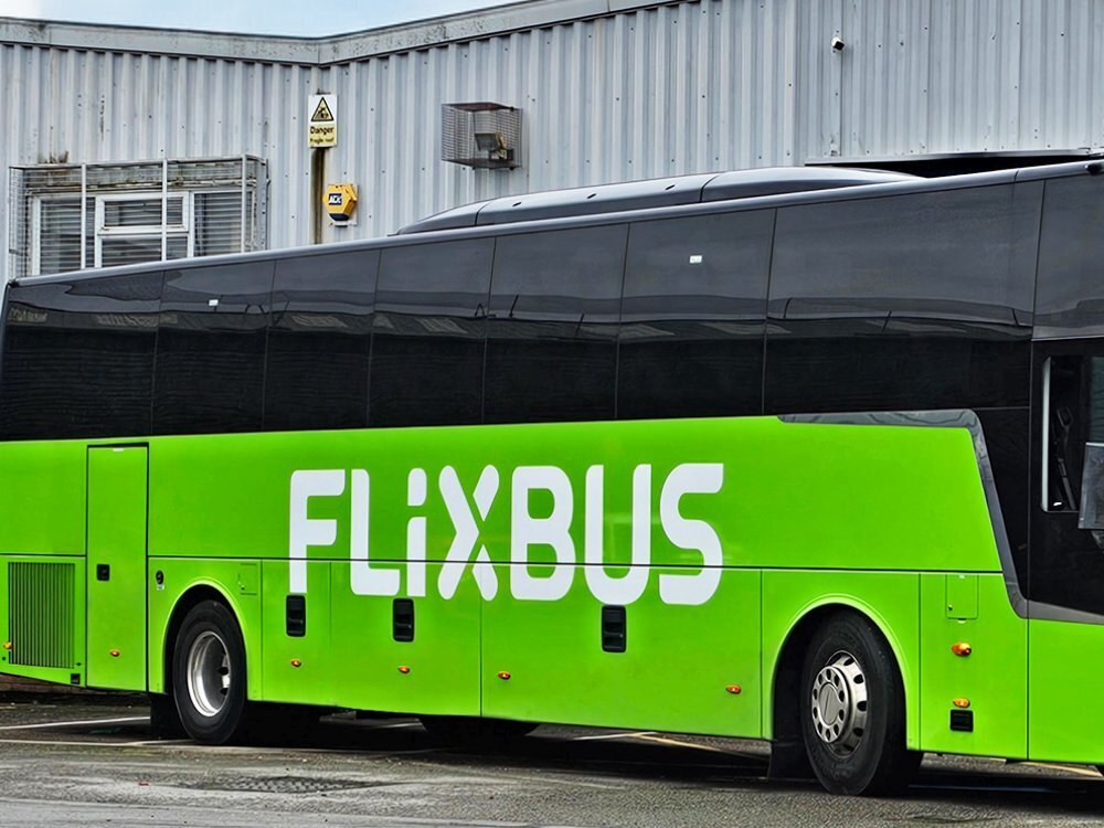 White Flixbus vinyl graphics on Van Hool coach with lime green livery.