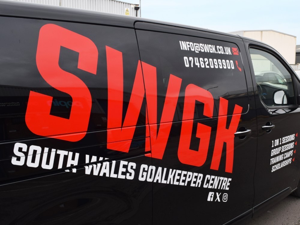 Bold red and white vehicle vinyl graphics on black company van.